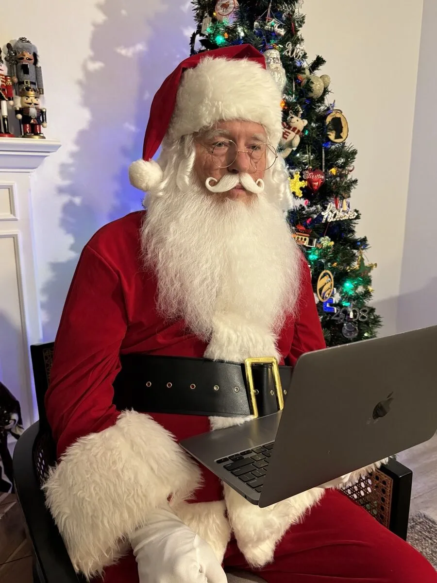 Santa smiling warmly into the camera on a video call