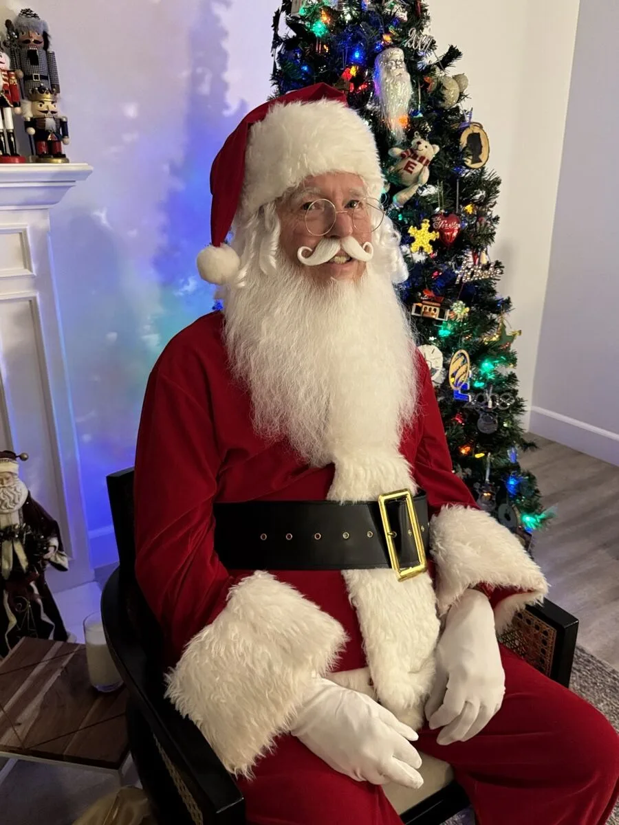 Santa smiling in his velvet suit and gold-buckled black belt